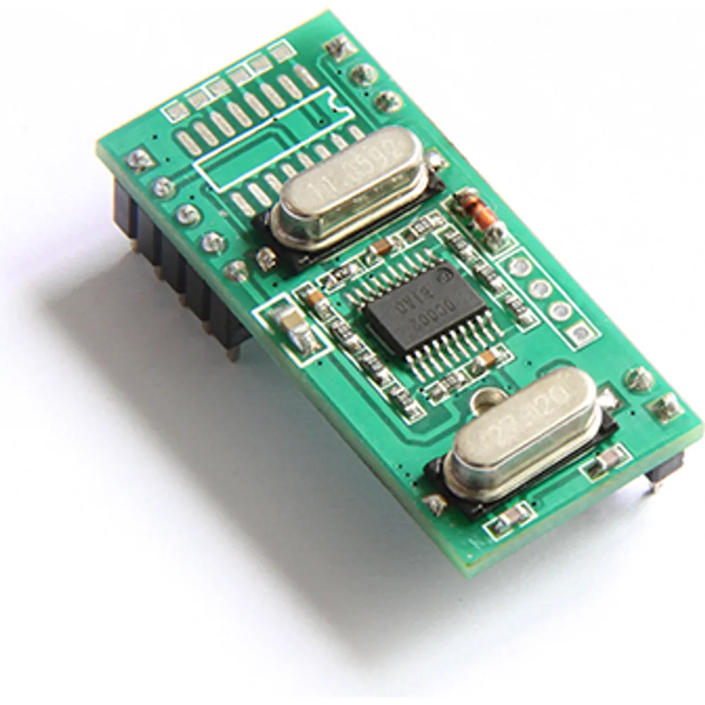 Narrow 13.56 MHz UID reader module with pin header along one edge and two crystals, angled view